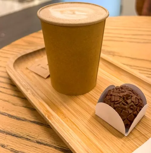 Café con leche para llevar con una trufa de chocolate